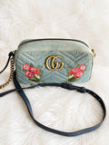 Gucci GG Marmont Denim Floral Embroidered Small Camera Bag featuring chevron-quilted blue denim and vibrant pink floral embroidery